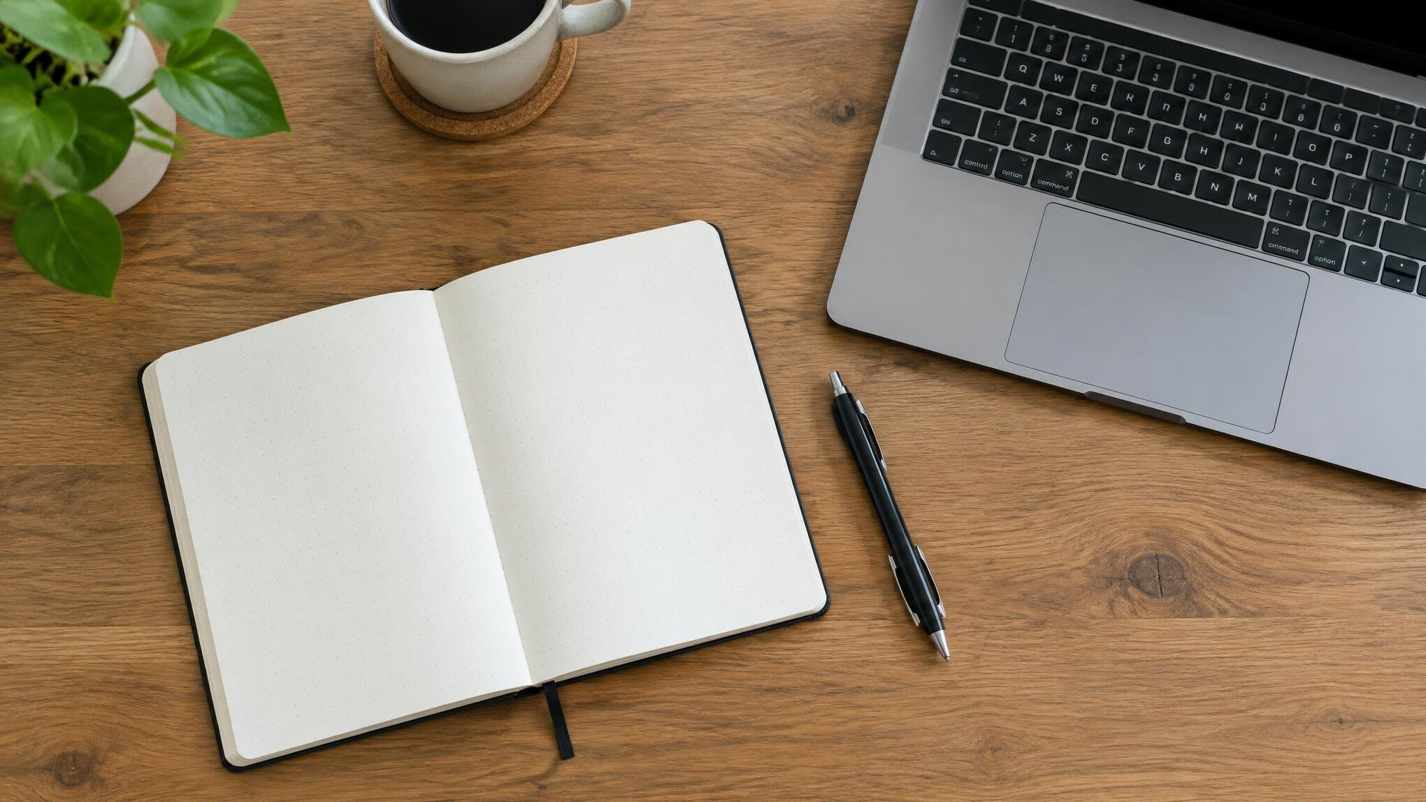 Open notebook and laptop on a wooden desk